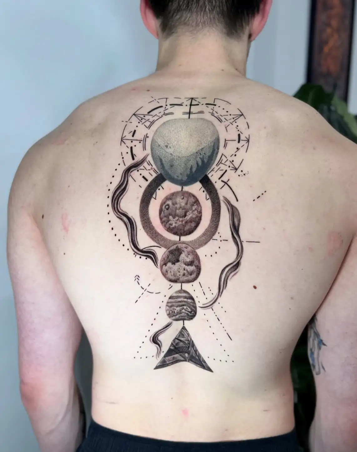 Cosmic back tattoo with planets and geometric elements by Ayah at Omnia Tattoo Melbourne